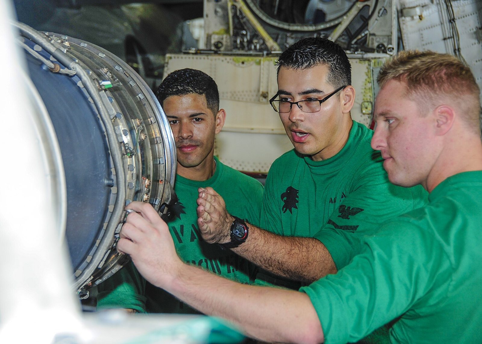 Maintenance technicians working on an aircraft engine in a hangar